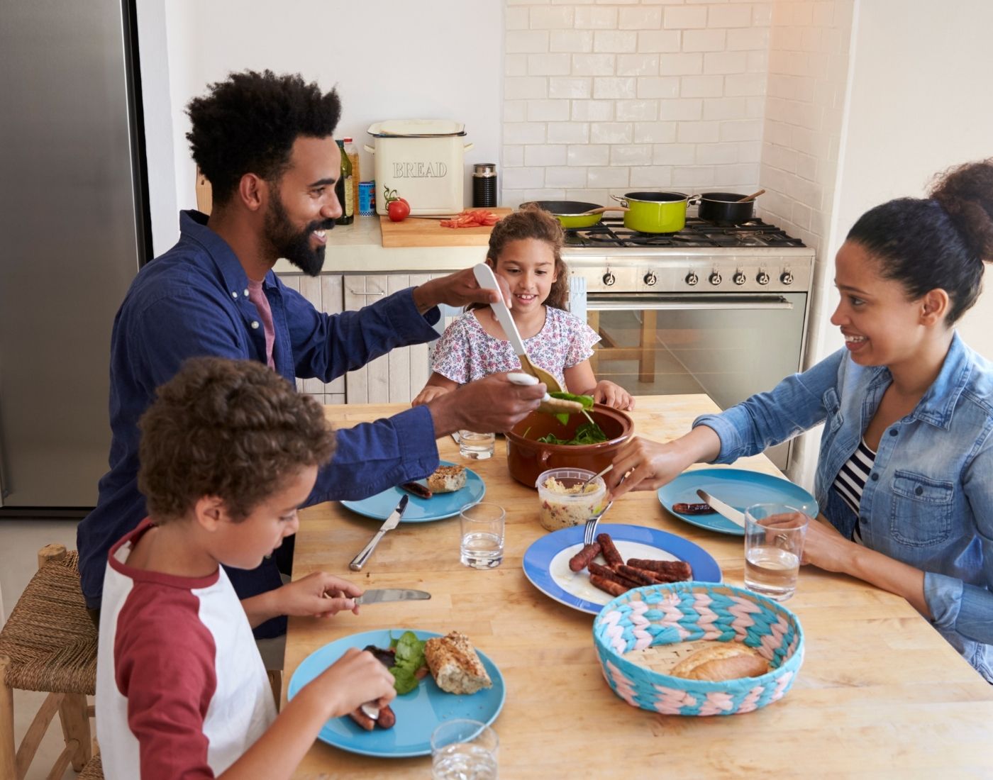Mum, dad and two children sitting at a table eating a healthy meal.