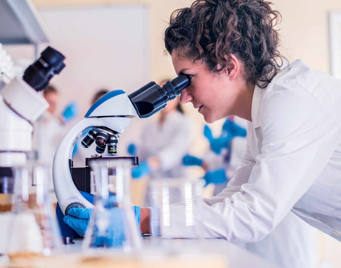 Female researcher looking through a microscope