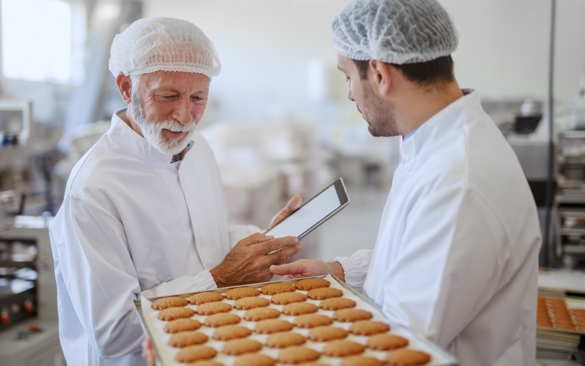 Two men in a kitchen, one conducting a health inspection.